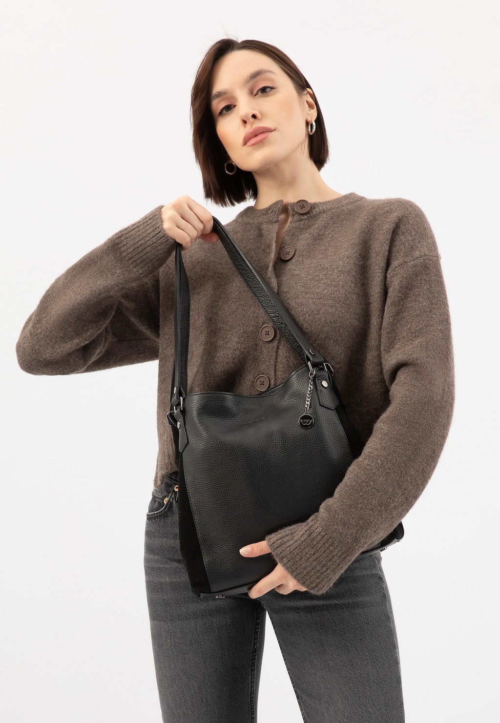 Modelka w brązowym swetrze prezentuje dużą czarną torebkę skórzaną Wojas model 9859-71 z regulowanym paskiem na ramieniu, idealną do codziennych stylizacji.