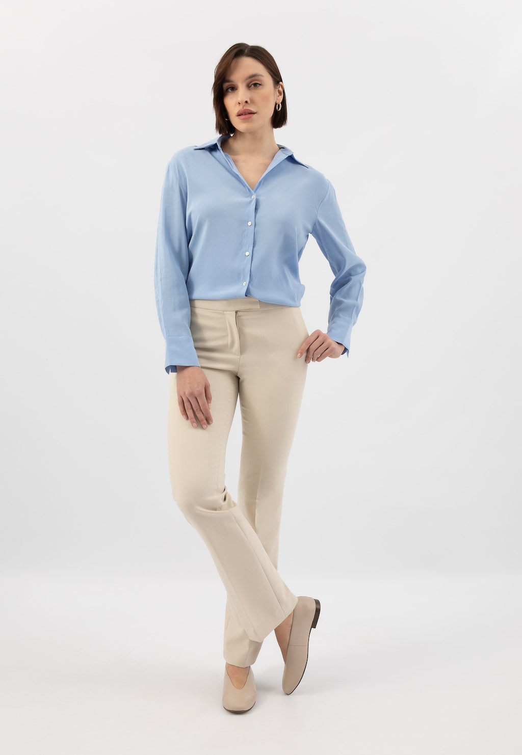 Elegancki strój biznesowy z beżowymi balerinami Wojas model 44030-54 ze skóry licowej, idealnie dopasowanymi do błękitnej koszuli i jasnych spodni.