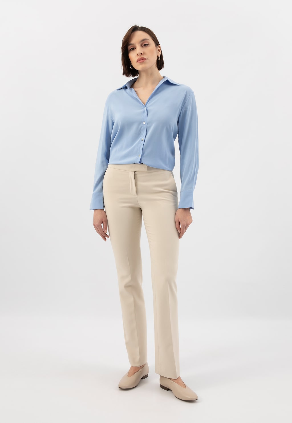 Osoba w eleganckim stroju z niebieską koszulą i beżowymi spodniami, prezentująca beżowe baleriny Wojas ze skóry licowej model 44030-54, widok na całą sylwetkę.