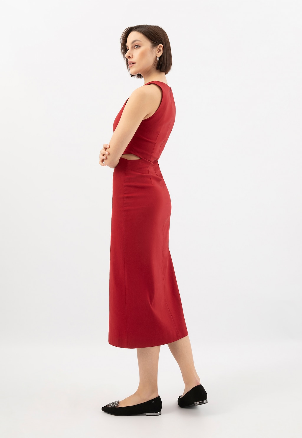 Elegancka czerwona sukienka midi z wycięciem na plecach, noszona z czarnymi balerinami Wojas model 44050-81 ze srebrnymi akcentami i ozdobą w kształcie serca.