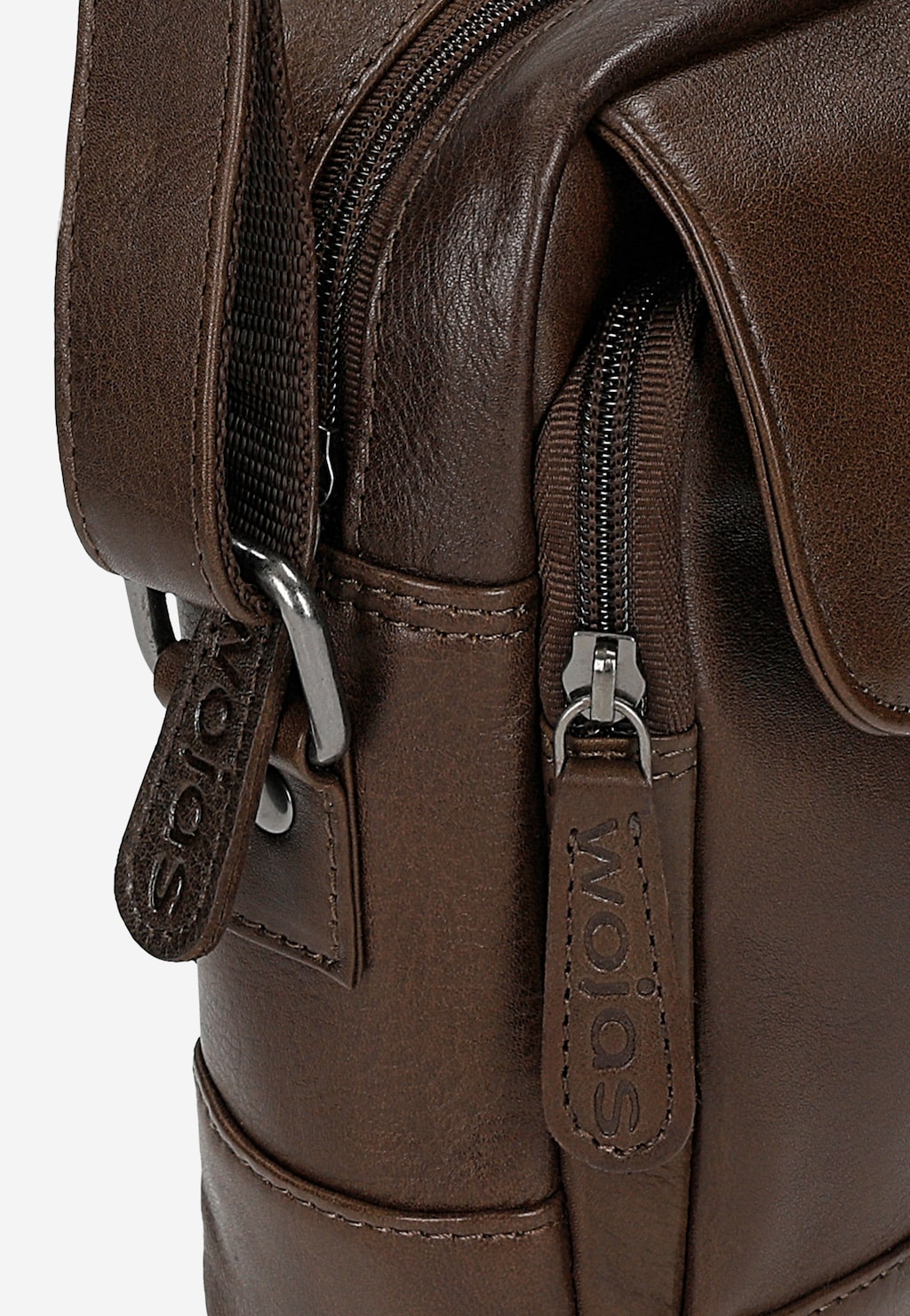 Zbliżenie na brązową torbę męską Wojas 90028-52 ze skóry naturalnej, ukazujące detale zamków błyskawicznych i skórzanych zawieszek z wytłoczonym logo marki.