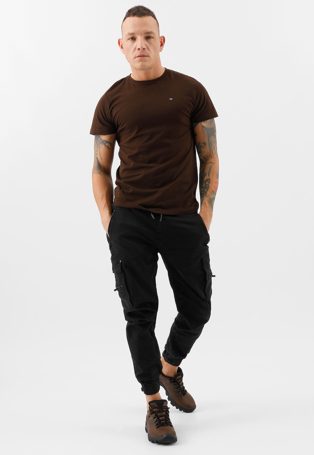 Osoba w brązowym t-shircie i czarnych spodniach cargo prezentująca brązowe męskie półbuty trekkingowe Wojas model 9377-92 w casualowej stylizacji.