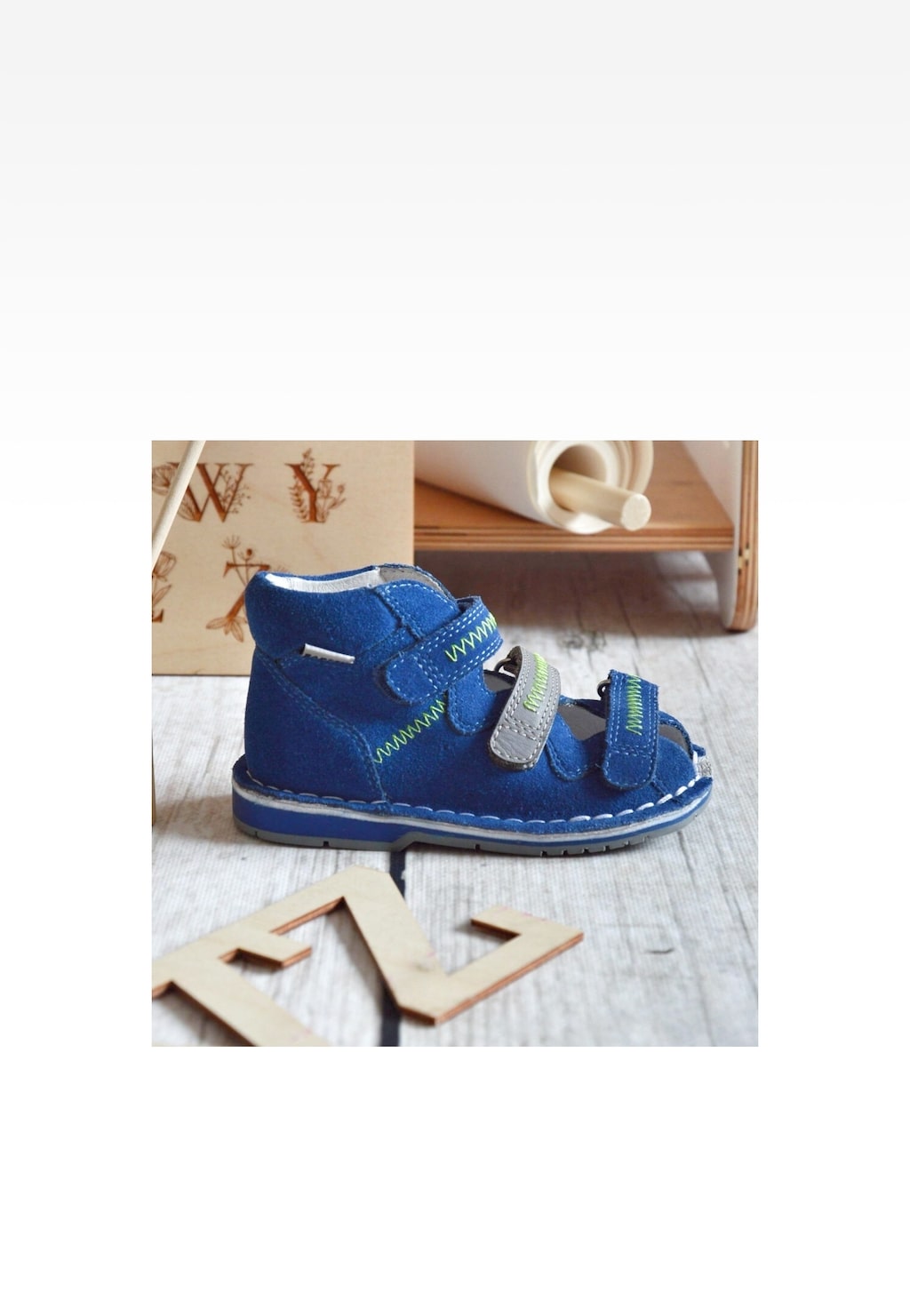 Niebiesko-popielate sandały zabudowane BARTEK 8920066 dla chłopców z zapięciem na rzepy, ozdobione zielonymi przeszyciami, ustawione na drewnianej podłodze.