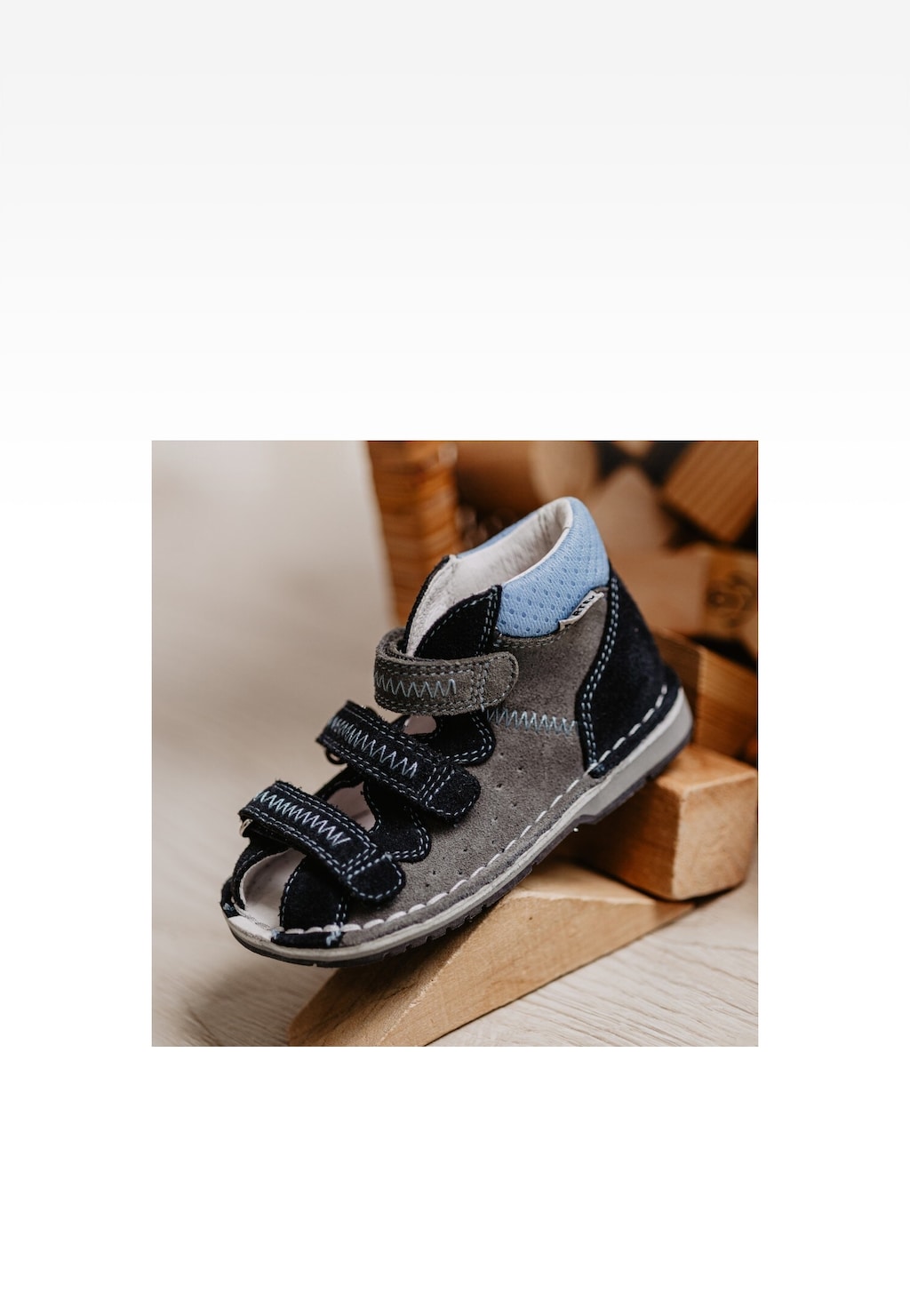 Sandały zabudowane Bartek 8920060 dla chłopców w kolorze popielato-granatowym z trzema zapięciami na rzepy, widoczne z boku na drewnianym tle.