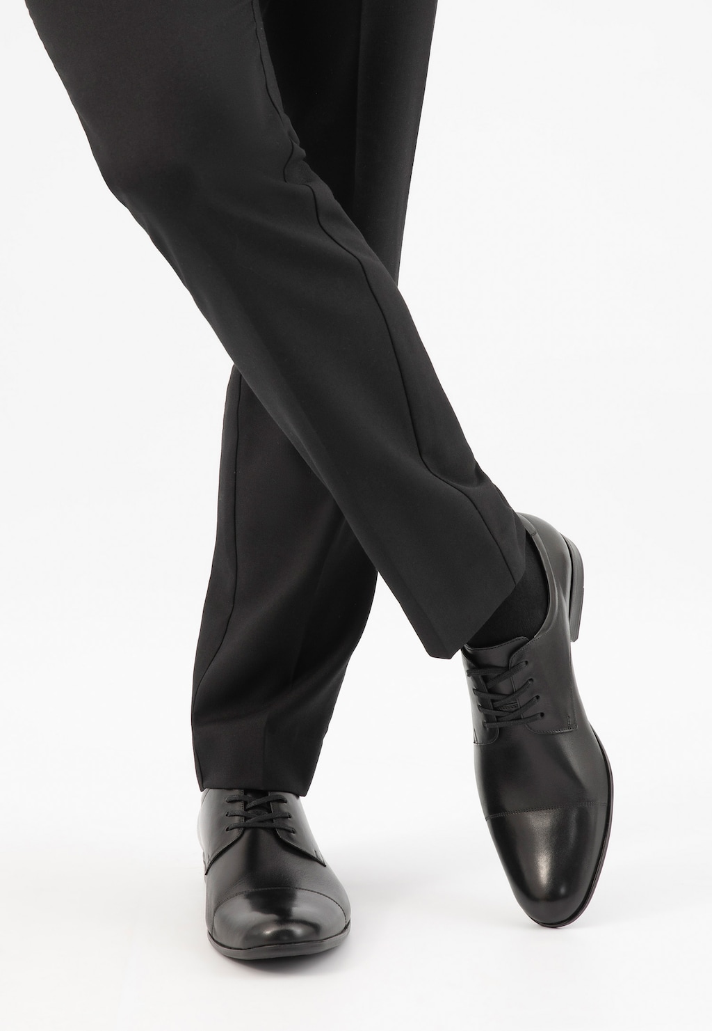 Eleganckie czarne półbuty męskie Wojas model 9036-51 z połyskującą skórzaną cholewką i czubkiem, widoczne na nogach w ciemnych spodniach garniturowych.