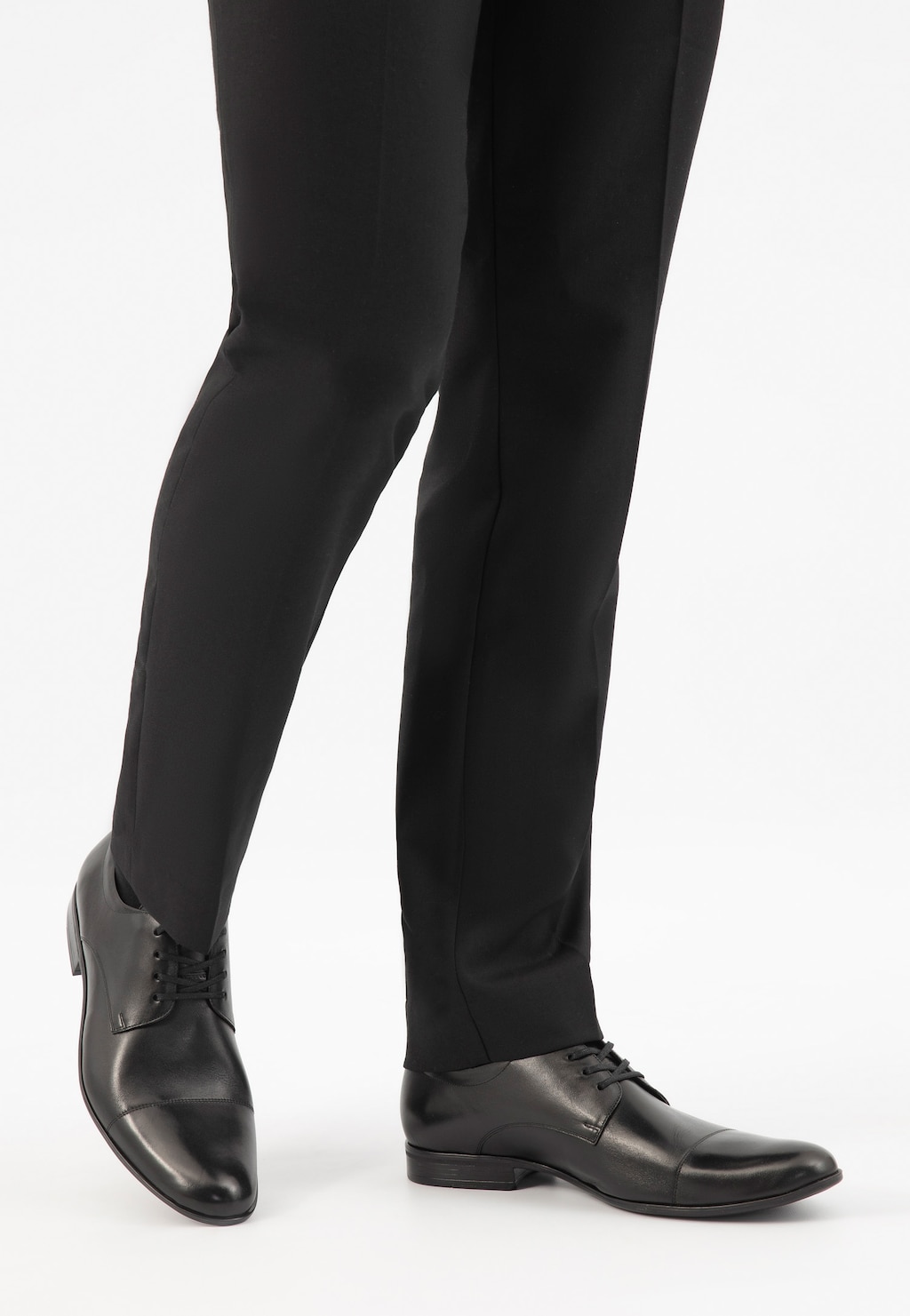 Czarne męskie półbuty Wojas model 9036-51 na nogach mężczyzny w eleganckich spodniach. Klasyczny skórzany fason idealny do stroju biznesowego.