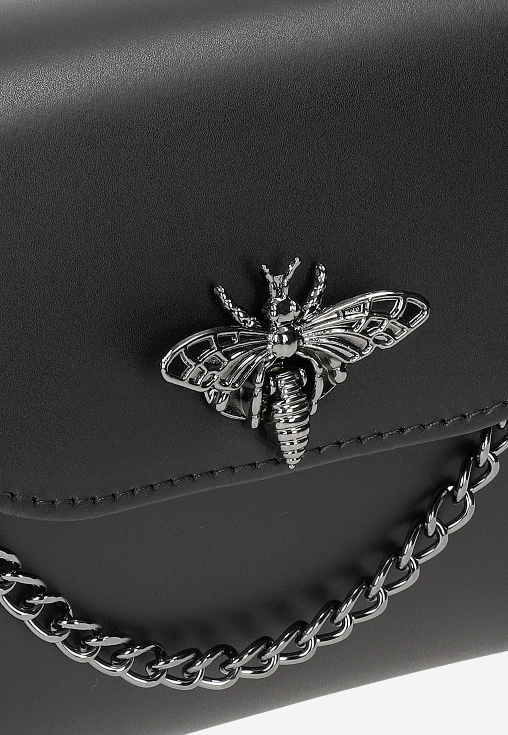 Czarna elegancka torebka wizytowa Wojas 80318-51 z ozdobną srebrną broszką w kształcie pszczoły i łańcuszkiem. Zbliżenie na dekoracyjny detal.