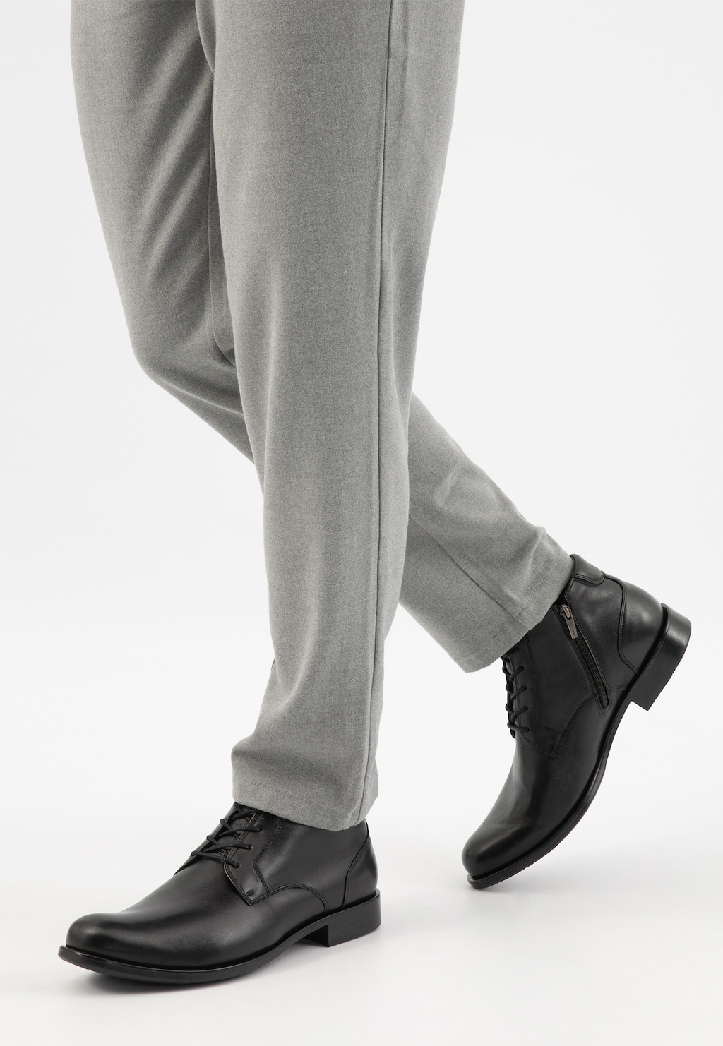 Czarne zimowe trzewiki męskie Wojas 9081-50 ze skóry licowej z bocznym zamkiem, noszone z eleganckimi szarymi spodniami. Stylowe obuwie do formalnych i codziennych stylizacji.