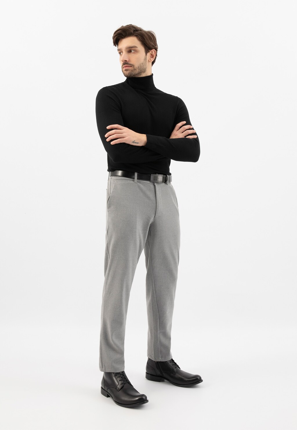 Model w eleganckim stroju prezentujący czarne zimowe trzewiki męskie Wojas 9081-50 ze skóry licowej w stylizacji z czarnym golfem i szarymi spodniami.