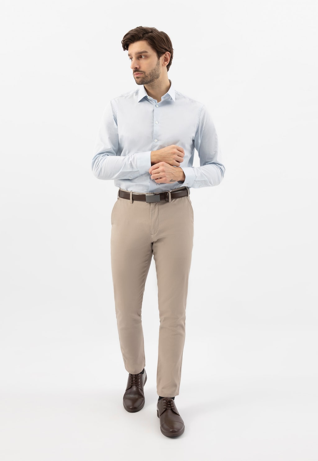 Elegancka stylizacja męska z brązowymi półbutami Wojas model 10073-52, jasną koszulą i beżowymi spodniami. Buty ze skóry licowej harmonizują z całym zestawem.