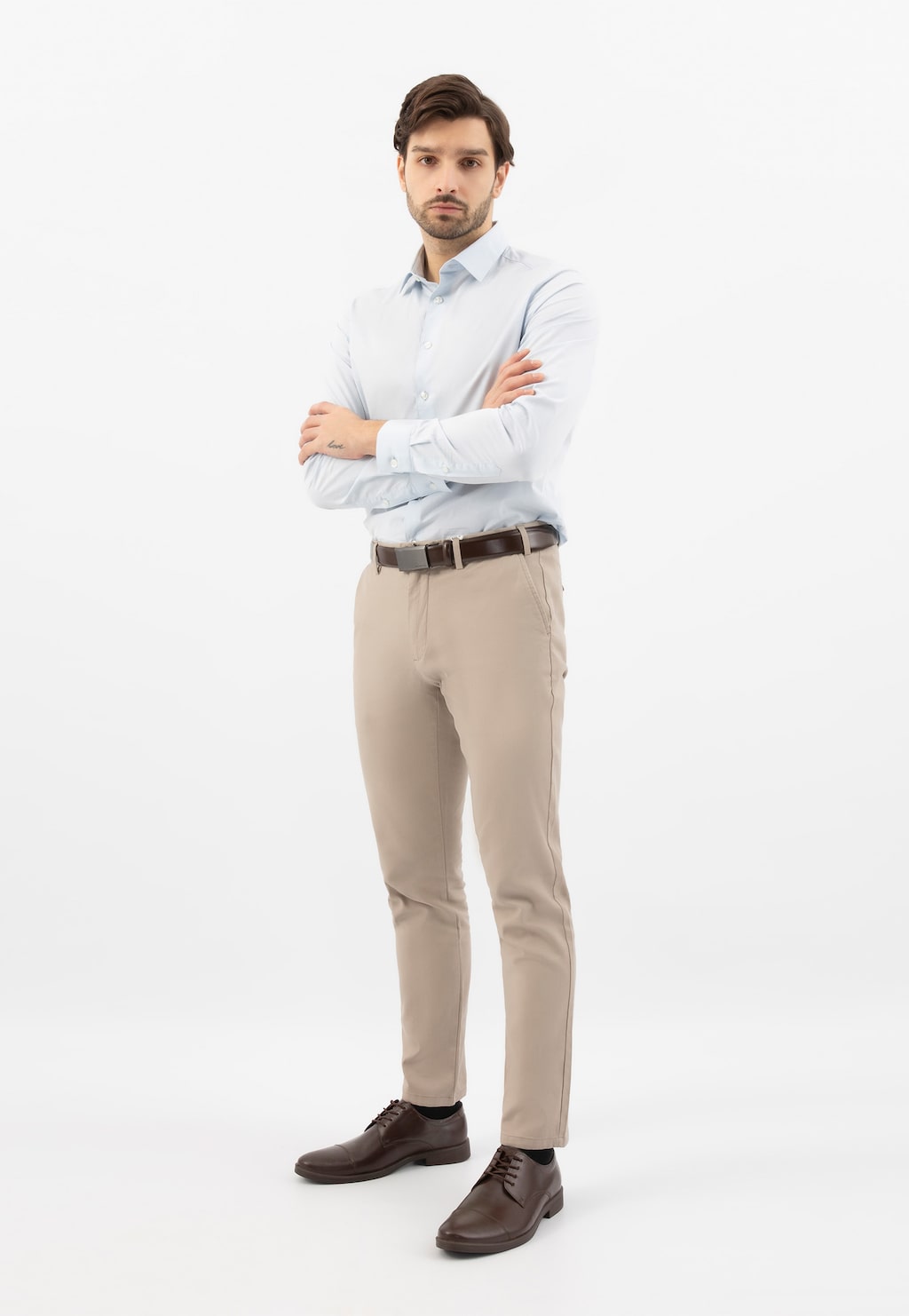 Mężczyzna w eleganckim stroju biznesowym prezentujący brązowe sznurowane półbuty Wojas model 10073-52 ze skóry licowej, widoczne w stylizacji z jasnymi spodniami i błękitną koszulą.
