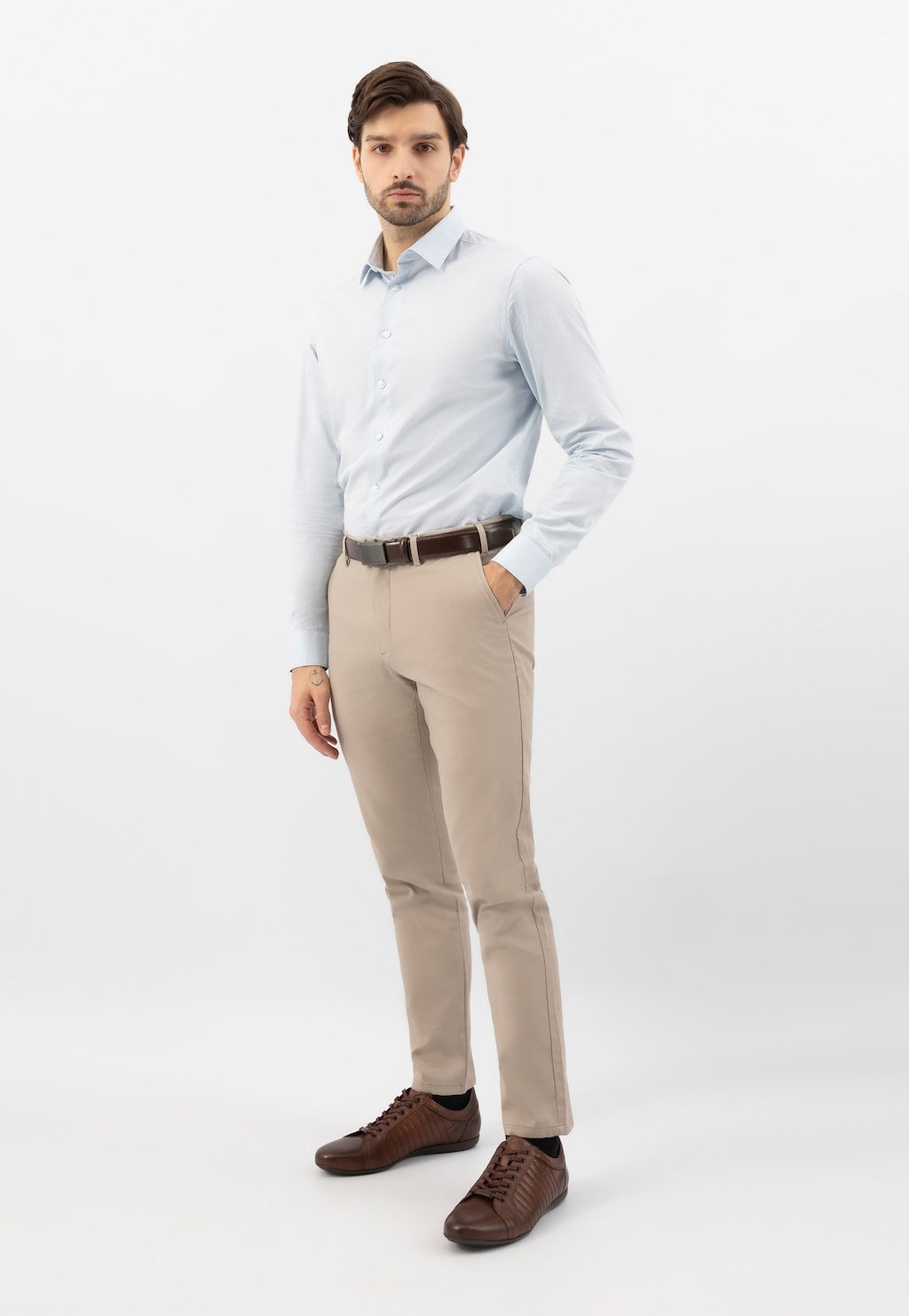 Model w eleganckim stroju z brązowymi skórzanymi sneakersami Wojas 10240-52 z charakterystycznymi przeszyciami, idealnie dopełniającymi biznesowo-casualowy look.