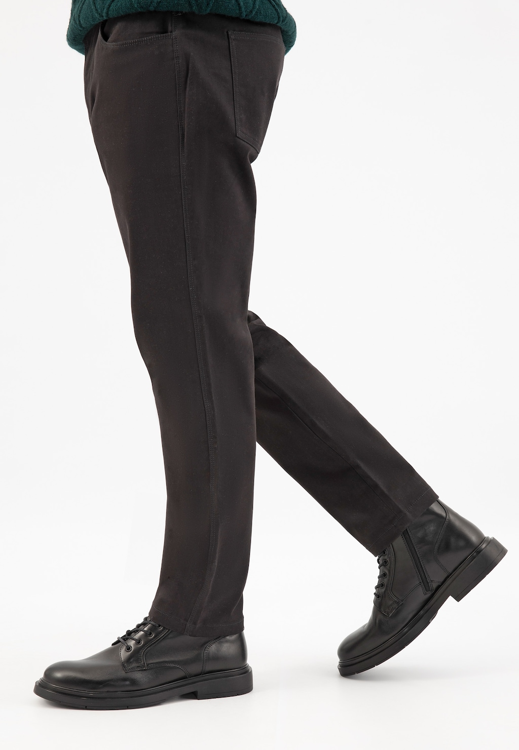 Czarne męskie bikery Wojas 24106-51 ze skóry licowej na nogach w ciemnych spodniach. Widok z boku podkreśla klasyczny fason butów z zaokrąglonym noskiem i sznurowaniem.