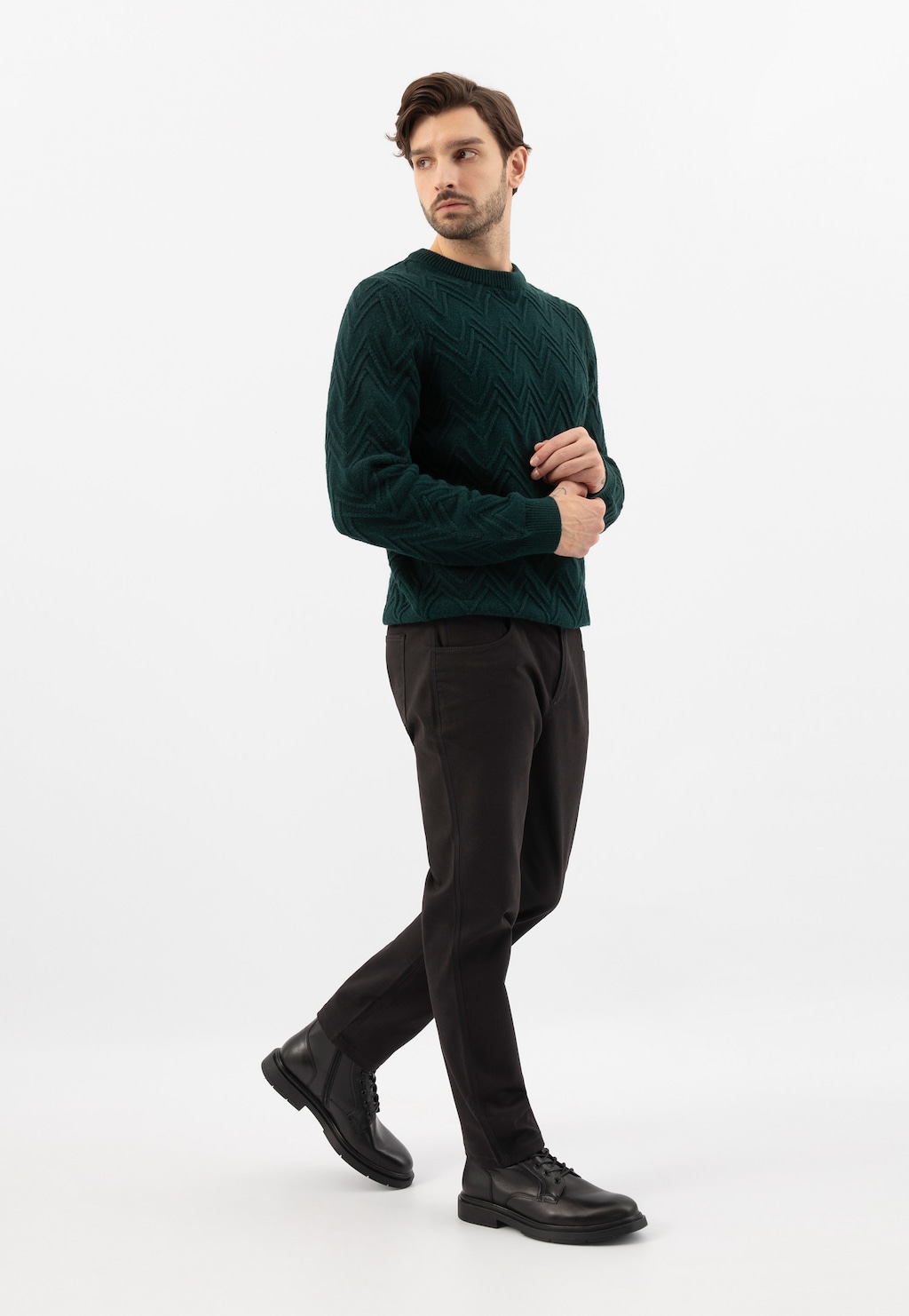 Osoba w ciemnozielonym swetrze i ciemnych spodniach prezentująca czarne bikery Wojas model 24106-51 ze skóry licowej podczas chodu.