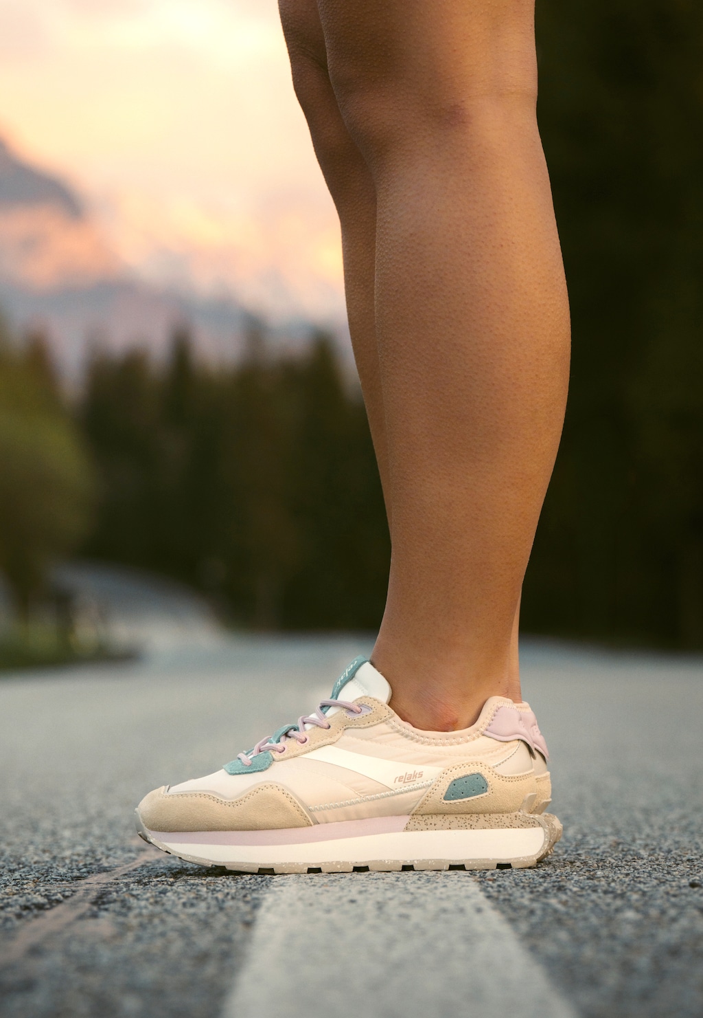 Pastelowe sneakersy damskie RELAKS R46180-14 na masywnej podeszwie w kolorach beżu, różu i mięty, noszone na drodze w górskim otoczeniu.
