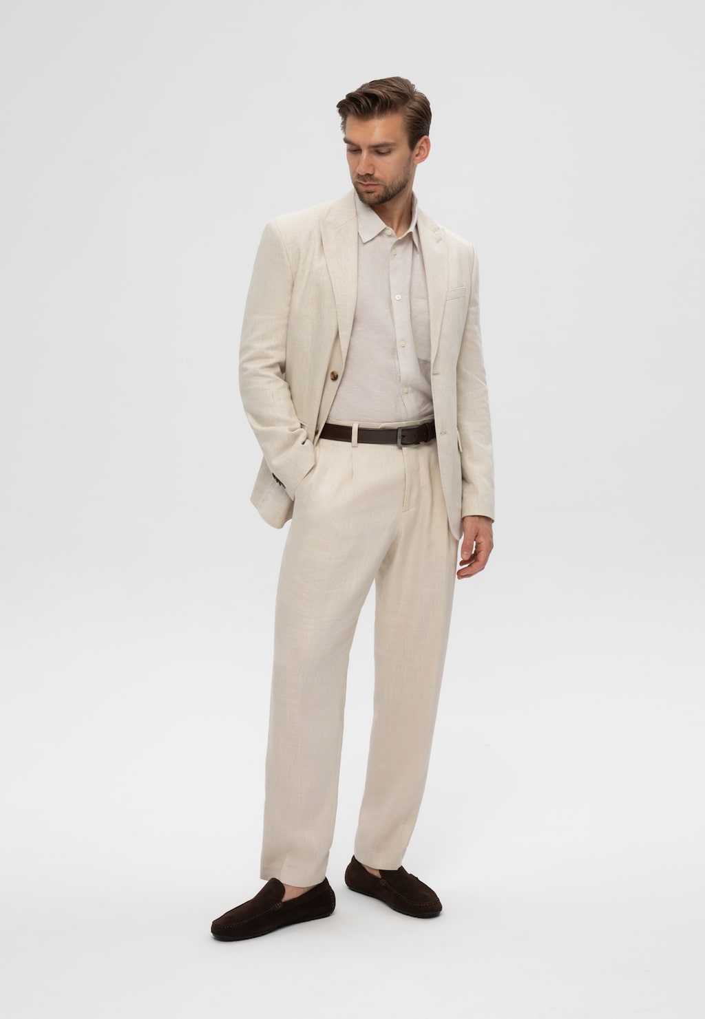 Mężczyzna w beżowym garniturze noszący ciemnobrązowe mokasyny męskie Wojas z dwoiny model 10308-62, stylizacja casual elegance.