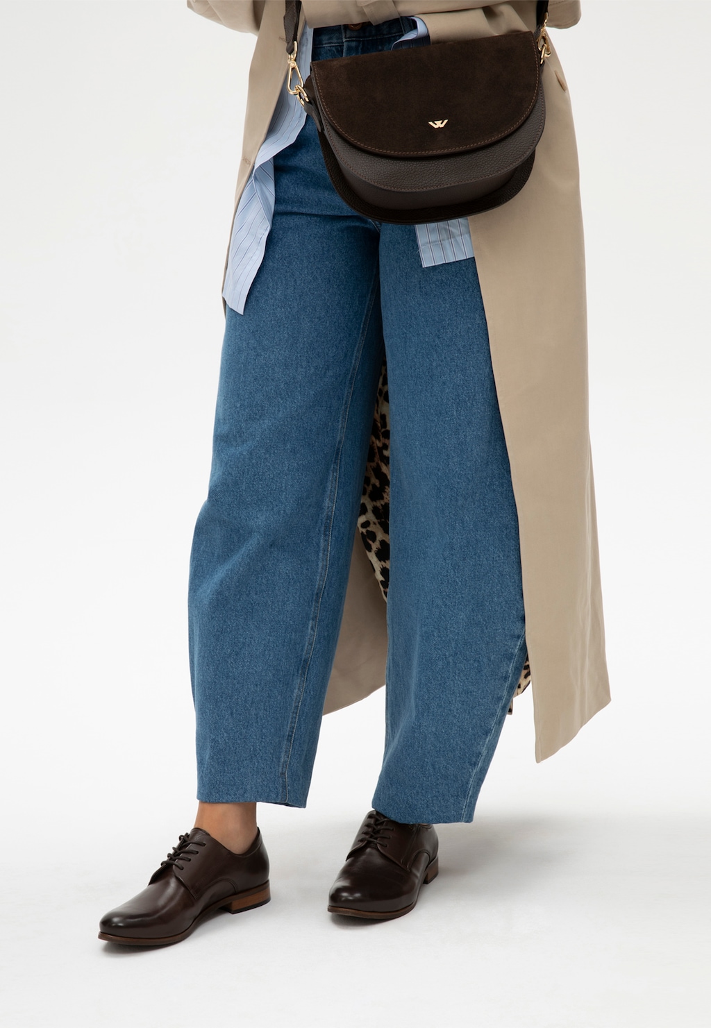 Damskie czekoladowe oksfordki Wojas model 6462-53 ze skóry licowej na nodze kobiety w jeansach i trenczu z torebką crossbody.