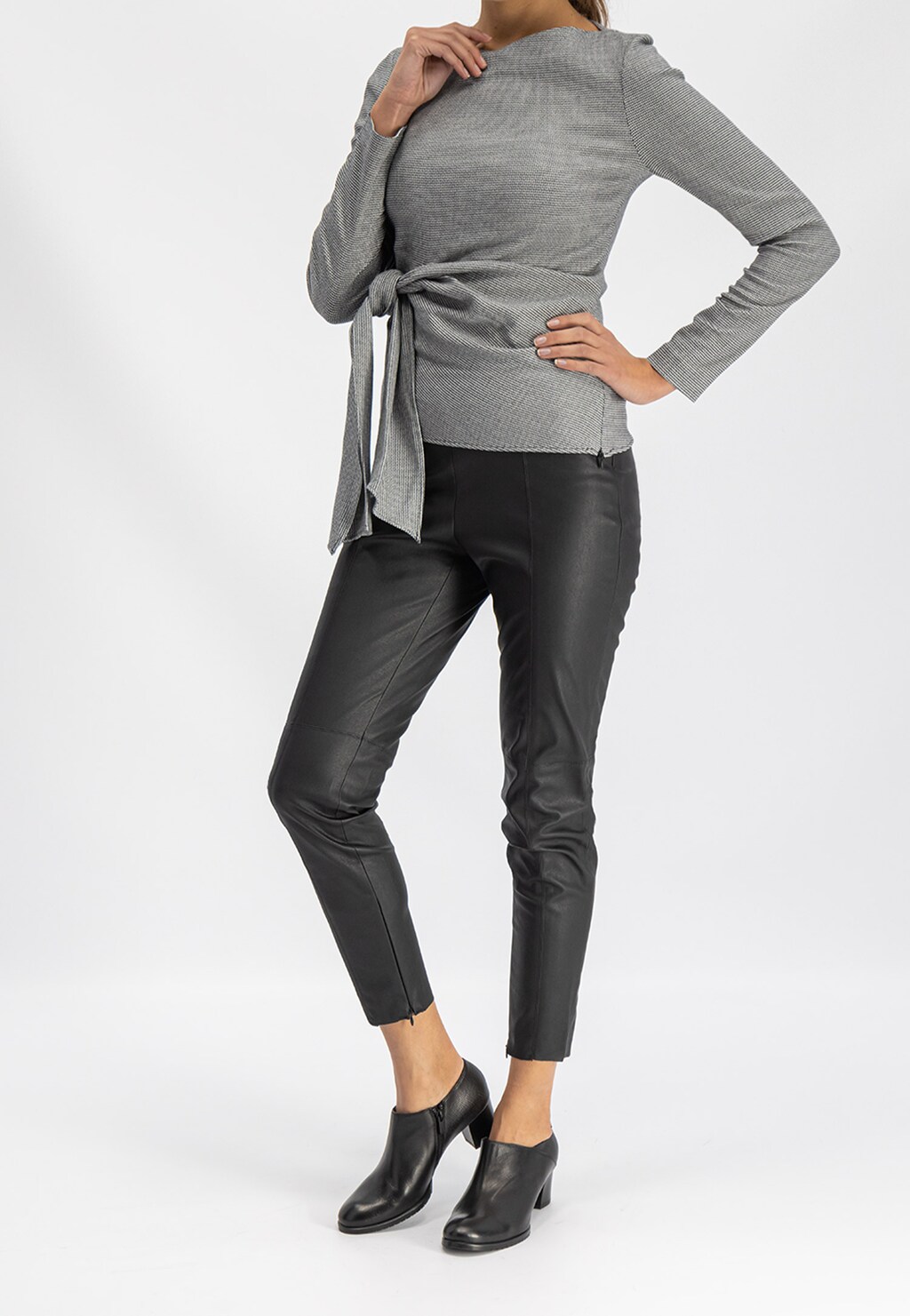 Elegancki strój z czarnymi półbutami Wojas 9494-51 na niskim słupku, idealny do stylizacji z szarą bluzką z wiązaniem i czarnymi skórzanymi spodniami.