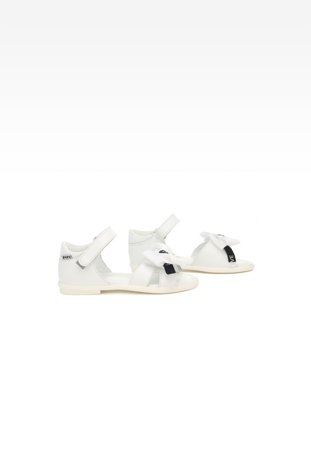 Białe sandały dziewczęce Bartek 19041001 z ozdobną kokardką, zapinane na rzep, widok z boku ukazujący elegancki profil i detale obuwia letniego.