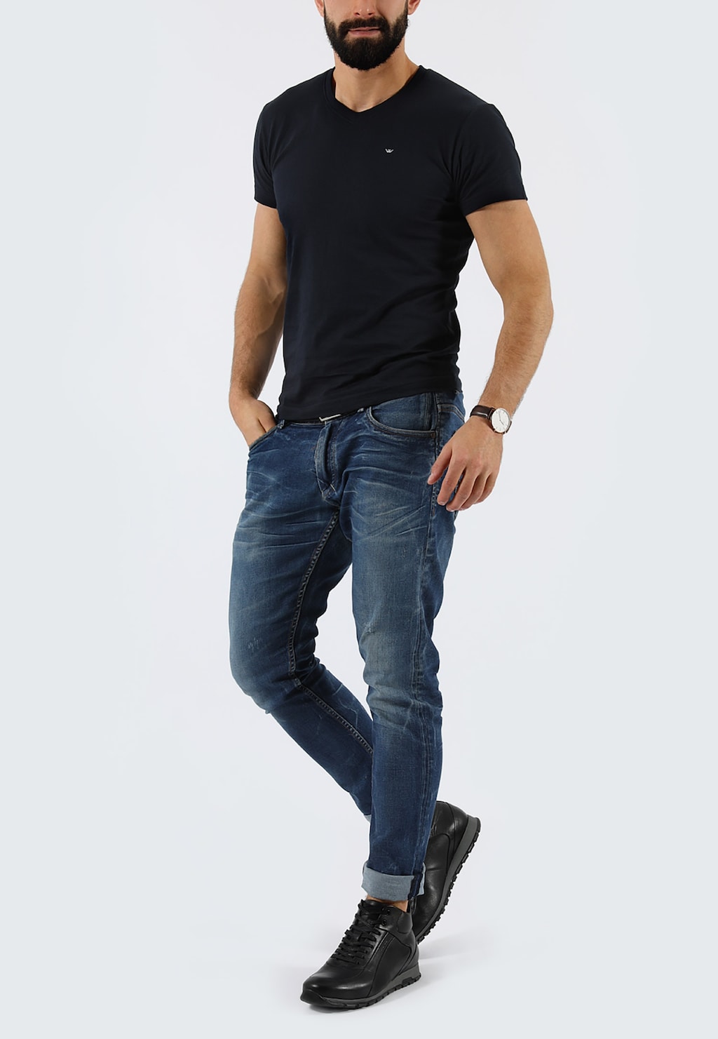 Mężczyzna w czarnej koszulce i dżinsach prezentujący trzewiki męskie Wojas model 9166-51 w kolorze czarnym, widoczne na stopach jako eleganckie buty do codziennych stylizacji.