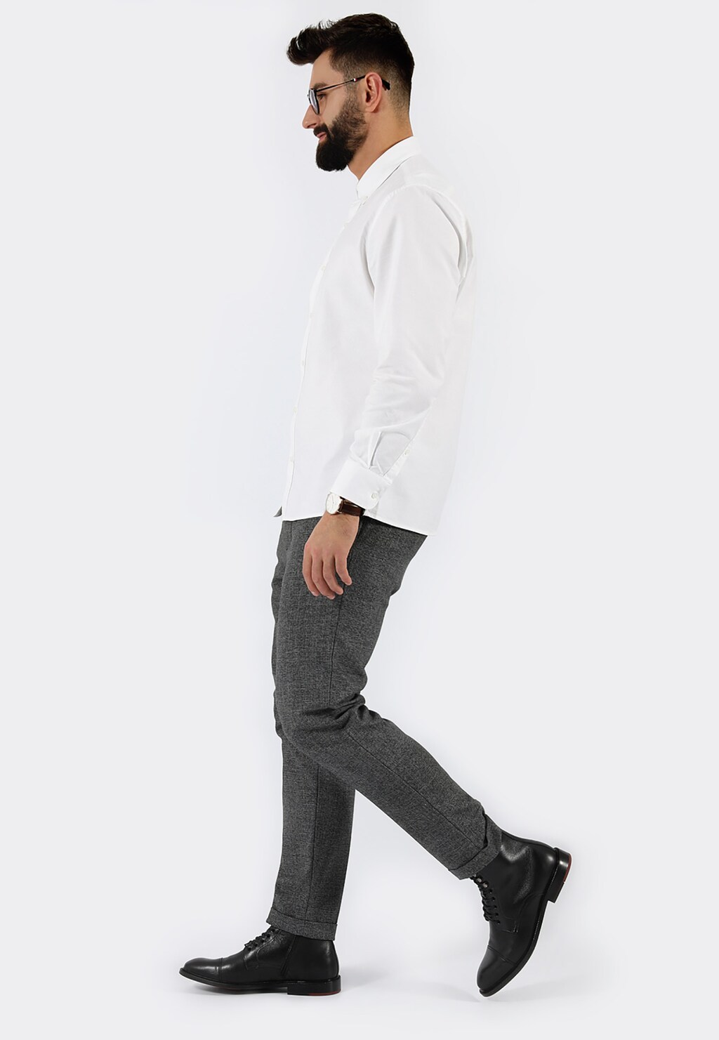 Mężczyzna w białej koszuli i szarych spodniach prezentujący czarne trzewiki męskie Wojas model 9171-51 ze skóry licowej, widok z boku podczas chodzenia.