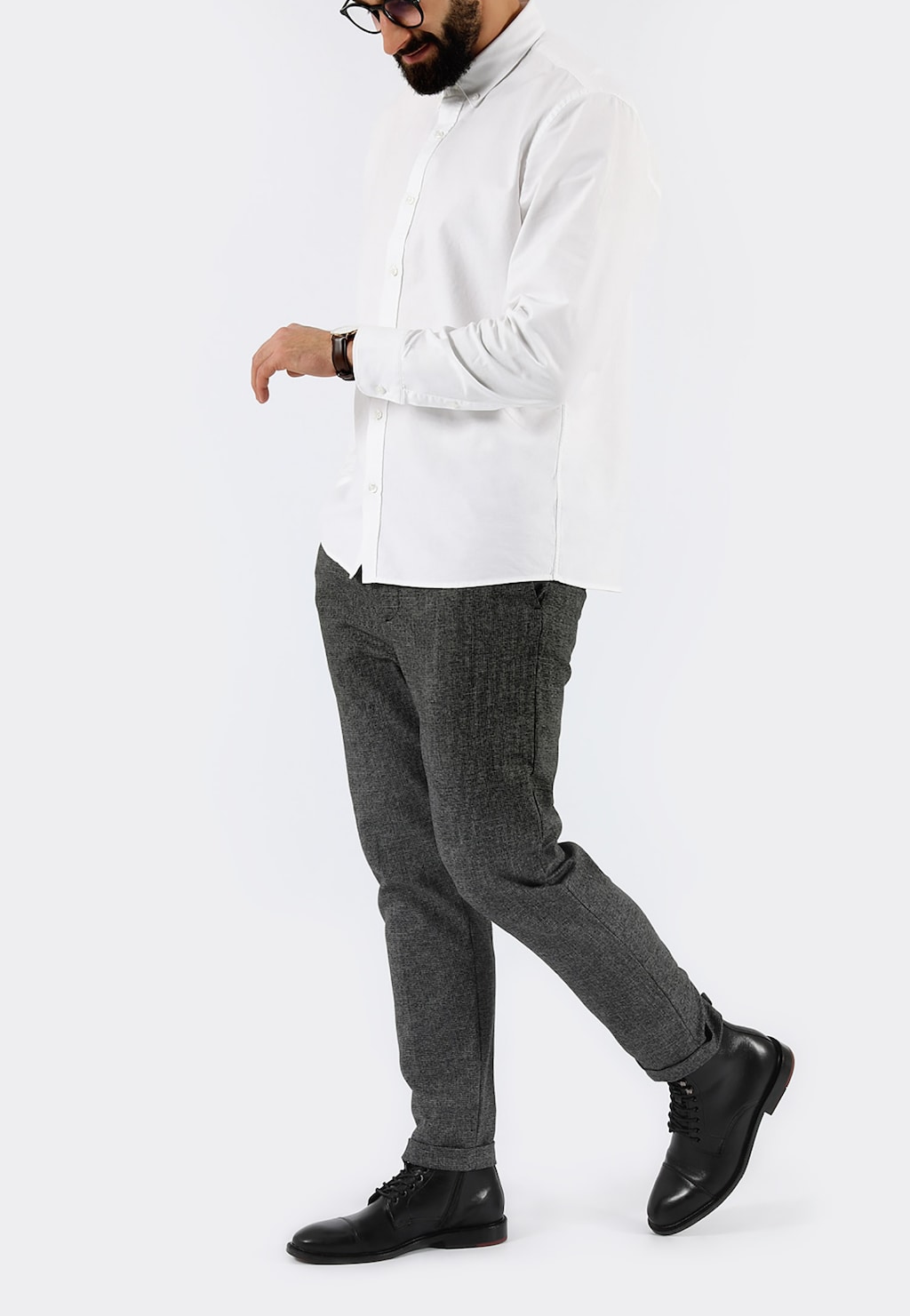 Mężczyzna w eleganckim stroju prezentujący czarne trzewiki męskie Wojas model 9171-51 ze skóry licowej, w połączeniu z białą koszulą i szarymi spodniami.