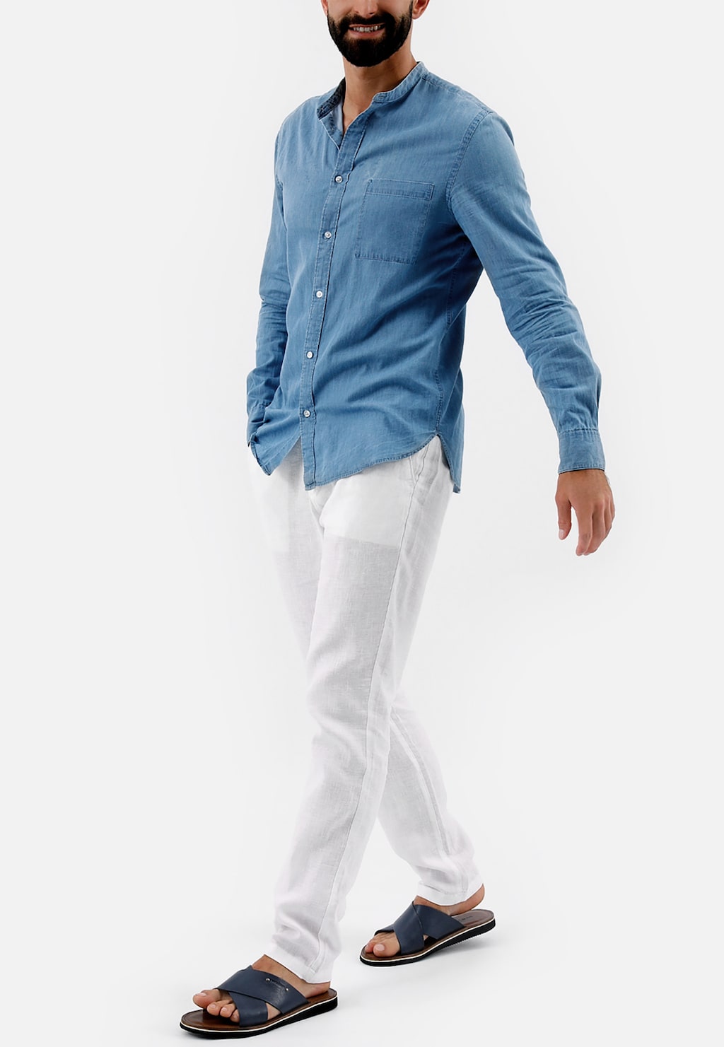 Mężczyzna w błękitnej koszuli i białych spodniach prezentujący granatowe klapki Wojas model 9259-56 ze skóry licowej, widoczne na stopach w całej sylwetce.