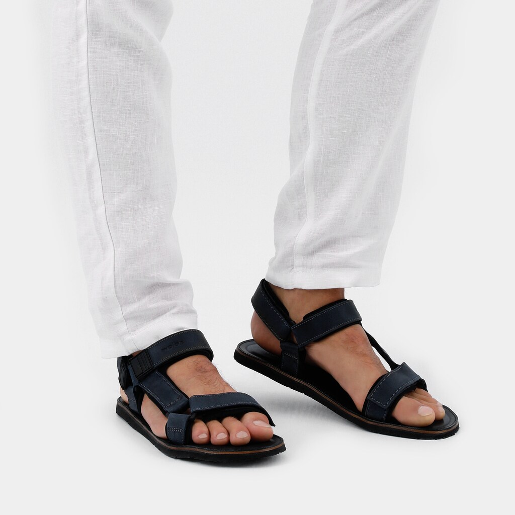 Granatowe sandały męskie Wojas model 29003-96 z regulowanymi paskami, na stopach mężczyzny ubranego w białe spodnie, widok z perspektywy frontalnej.
