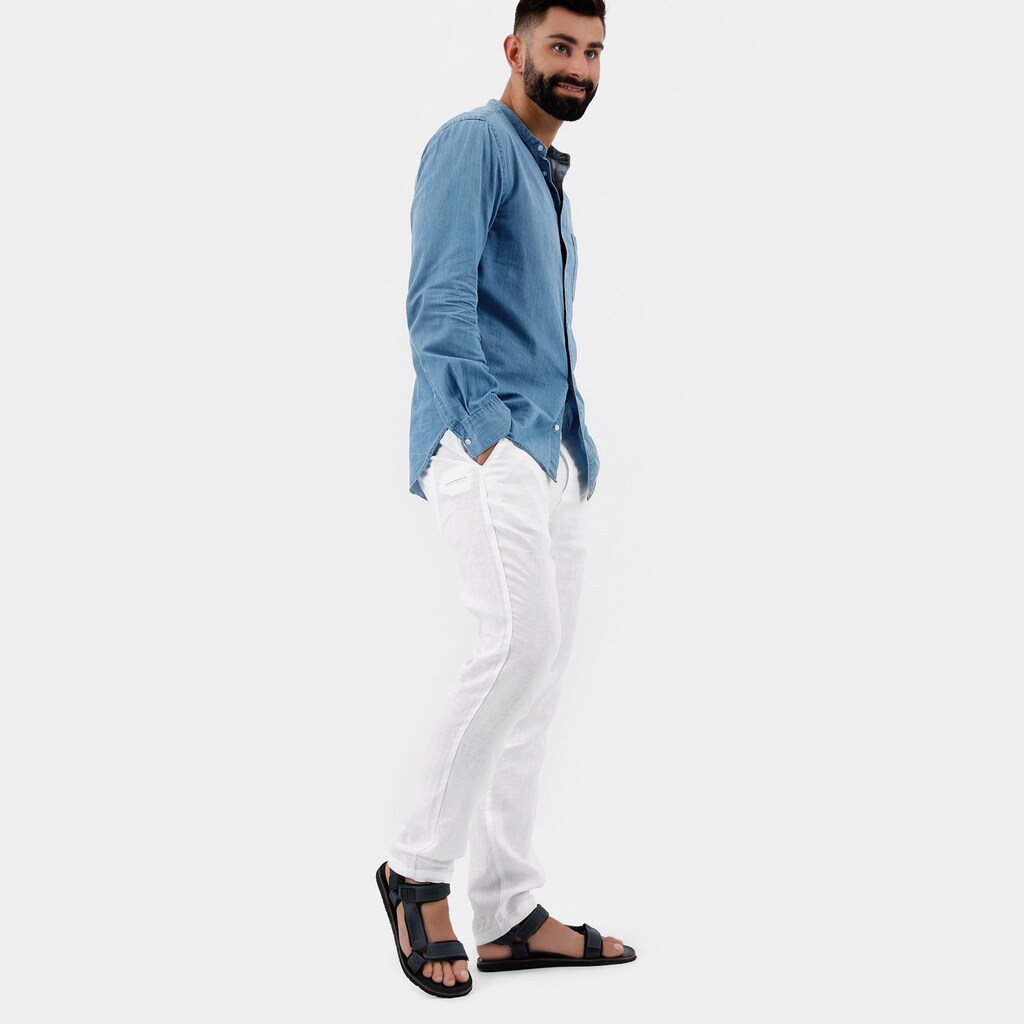 Mężczyzna w niebieskiej koszuli i białych spodniach prezentujący granatowe sandały męskie Wojas model 29003-96 z regulowanymi paskami, widok z boku.