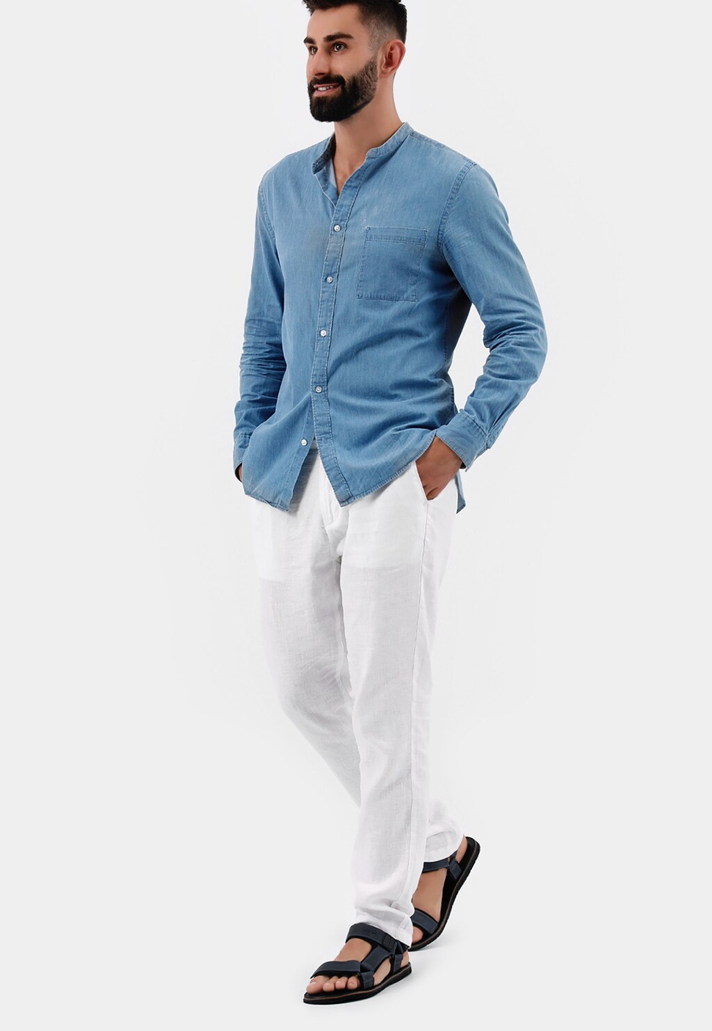 Mężczyzna w niebieskiej koszuli i białych spodniach prezentujący granatowe sandały męskie Wojas model 29003-96 z regulowanymi paskami, widoczne na stopach.