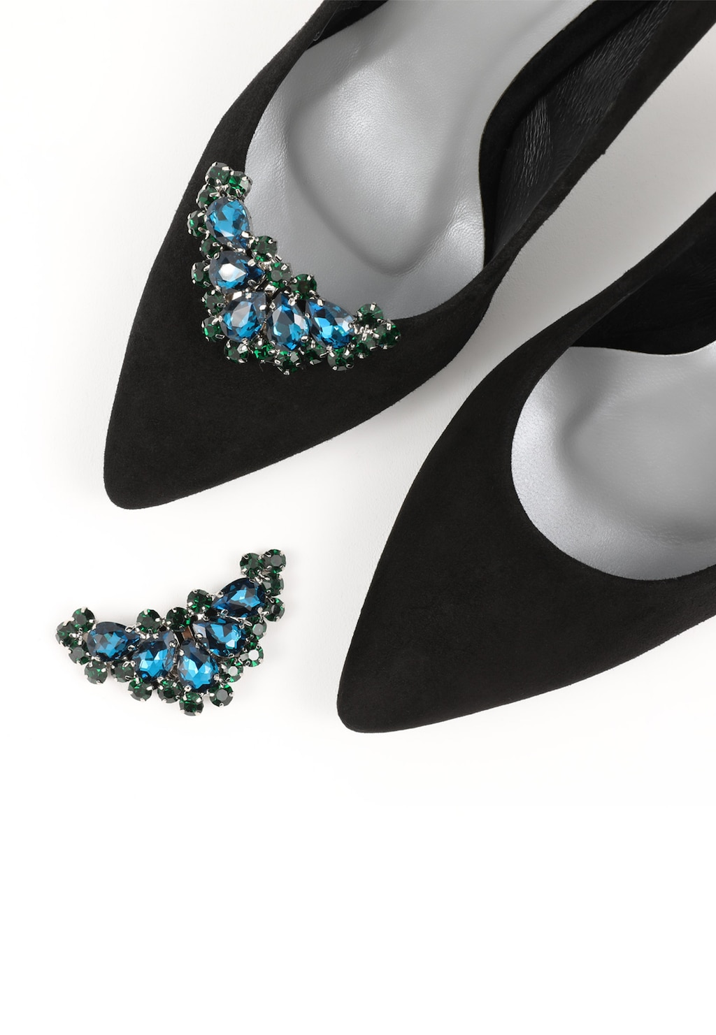 Eleganckie zielono-czarne ozdoby do obuwia Wojas model 98513-17 z błyszczącymi niebiesko-zielonymi kryształami, prezentowane przy czarnych butach na szpilce z ostrym noskiem.